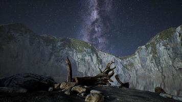 hyperlapse of night starry sky with mountain and ocean beach in Lofoten Norway photo