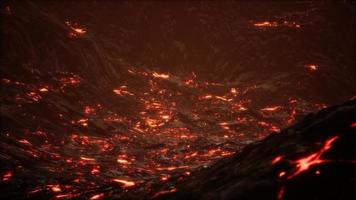 Red Orange vibrant Molten Lava flowing onto grey lavafield and glossy rocky land photo