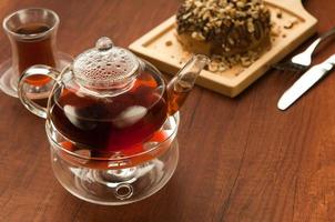 Transparent glass teapot and cup with tea photo