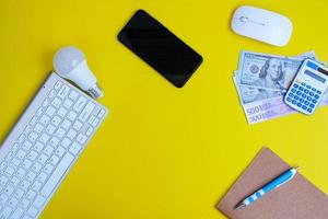 Blank notebook with pen is placed on an office desk table with computer tools and a range of materials. finance and banking background, flat lay, top view photo