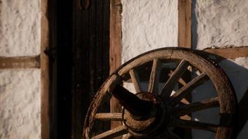 old wood wheel and black door at white house photo