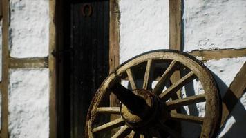 old wood wheel and black door at white house photo