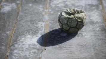 viejo balon de futbol el piso de cemento foto