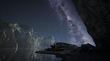 hiperlapso de cielo estrellado nocturno con playa de montaña y océano en lofoten noruega foto