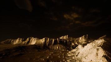 Dark clouds over volcanic valley with grass and rocks photo