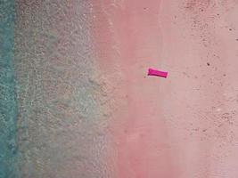 Drone aerial view of inflatable on exotic tropical pink beach photo