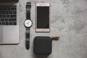 Flat lay top view of work concept with computer laptop and travel accessories on grey concrete wall photo