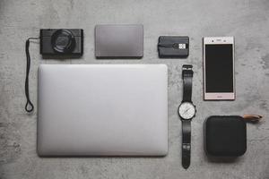 Flat lay top view of hipster or traveler accessories on grey concrete wall photo