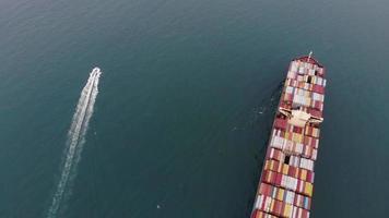Aerial top view of cargo maritime ship with contrail in the ocean ship carrying container and running for export  concept technology freight shipping by ship smart service