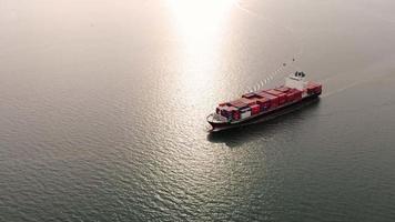 vista aerea frontale della nave da carico che trasporta container e funziona per l'esportazione di merci dal porto del cantiere merci al trasporto tecnologico personalizzato sull'oceano, sdoganamento. video