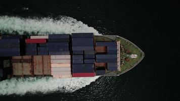 bovenaanzicht vanuit de lucht van vracht maritiem schip met contrail in de oceaan schip met container en rennen voor export concept technologie vracht verzending per schip slimme service video