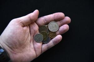 An outstretched hand with coins on a black background photo