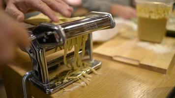 un cocinero trabaja con una máquina para hacer pasta italiana a partir de una masa video