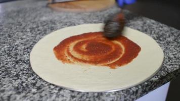 un cuisinier prépare une pizza avec tomate, mozzarella et salami video