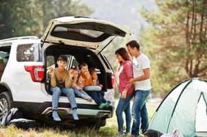 Large family of four kids. Children in trunk. Traveling by car in the mountains, atmosphere concept. American spirit. photo