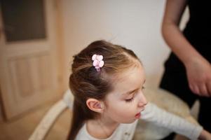 Mother and daughter weekend together at home, mom making hairstyle. photo