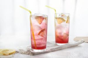 Homemade lemonade in glasses on white background in blur.