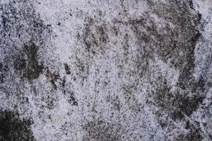 Old grunge dirty textured cement wall surface. With uneven stains and tiny holes. photo