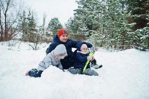 Father with two daughters in winter nature. Outdoors in snow. photo