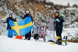 Scandinavian family with Sweden flag in winter swedish landscape. photo