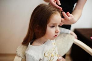 Mother and daughter weekend together at home, mom making hairstyle. photo