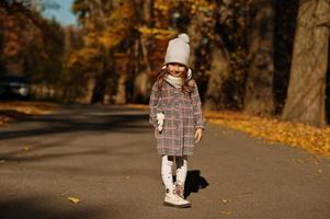 joven linda niña en pose de sombrero en el fondo de otoño. foto