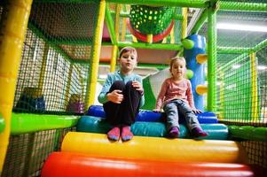 Brother with sister playing in indoor play center. photo