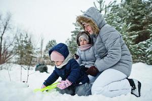 madre con dos hijas de niña en la naturaleza de invierno. al aire libre en la nieve. foto