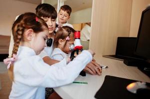 Kids using microscope learning science class at home. photo