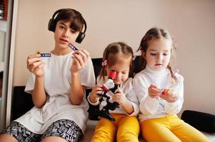 niños usando microscopio aprendiendo clases de ciencias en casa. foto