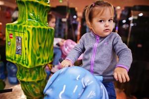 Two sisters rides an elephant carousel in fun children center. photo