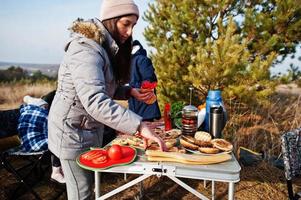 Family barbecuing on a deck in the pine forest. Bbq day with grill. photo