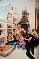 Happy family with four kids eating pizza at home. photo