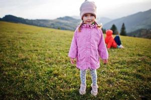 Cute baby girll in mountains. Little discoverer. photo