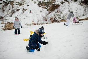 Family plays and sleigh rides in winter outdoor, mother and children having fun. photo