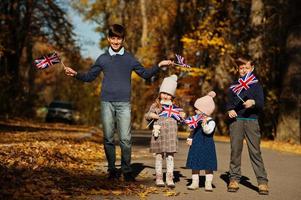 fiesta nacional del reino unido. cuatro niños con banderas británicas en el parque de otoño. britanicidad celebrando el Reino Unido. foto