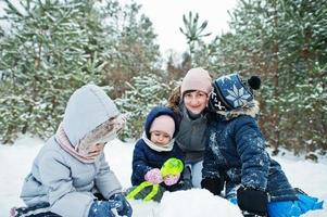 Mother with three children in winter nature. Outdoors in snow. photo
