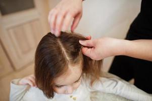 Mother and daughter weekend together at home, mom making hairstyle. photo