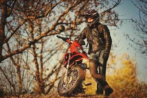 Motorcycle rider stay at sunset with him enduro bike