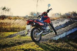 motocicleta enduro permanecer en el sol del atardecer foto