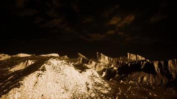 nubes oscuras sobre valle volcánico con hierba y rocas foto