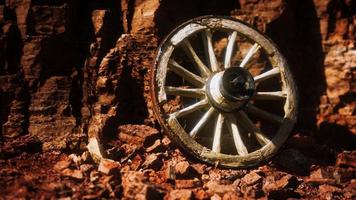 old wooden cart wheel on stone rocks photo