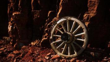 old wooden cart wheel on stone rocks photo