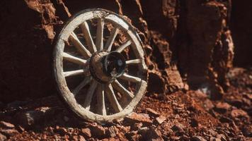 rueda de carreta de madera antigua sobre rocas de piedra foto