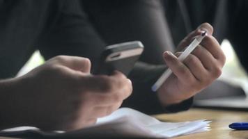 Two Men use Mobile Smart Phones in Hands during a Coffee Lunch in a Cafe video