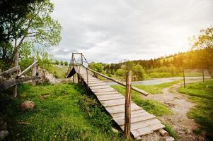 puente colgante de montaña de madera del río cárpato foto