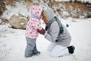 mamá con hija en invierno al aire libre, madre e hijos divirtiéndose. foto