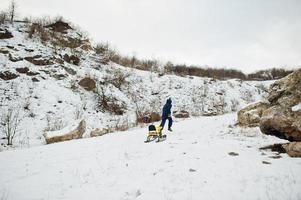 Boy enjoy a sleigh ride. Child sledding. Kid riding a sledge on winter. photo