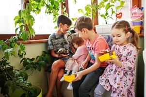 cuatro niños con sus mascotas favoritas en las manos. niños jugando con hámster, tortuga en casa. foto