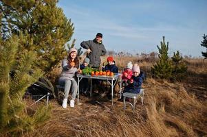 Cheerful large family at a picnic. On vacation with fruits outdoor. photo